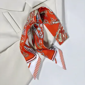 Détail d'un élégant foulard en soie orange twilly drapé sur le col d'un blazer crème