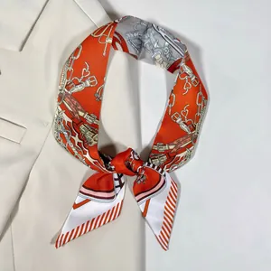 Détail d'un foulard en soie orange avec motifs équestres sur le revers d'une veste