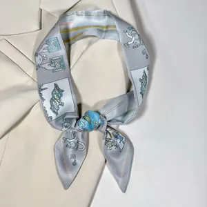 Detail of elegant printed twilly silk scarf tied on a beige blazer collar for work