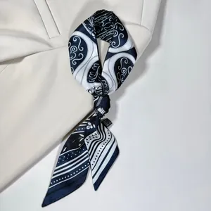 Dettaglio di un foulard in seta bianco e nero annodato su un blazer beige