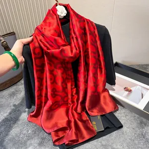 Luxurious red silk scarf with geometric patterns draped on an elegant display