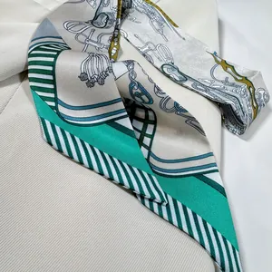 Détail d'un foulard en soie à imprimé équestre fleuri drapé sur un tissu beige