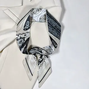 Dettaglio di sciarpa in seta paisley abbinata a un blazer bianco per un look da ufficio elegante
