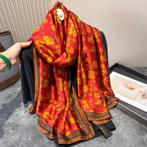 Detailed view of red silk scarf with golden Fu characters and decorative brown border