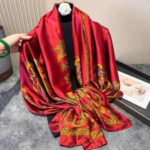 Detail of red silk scarf featuring golden phoenix patterns and elegant satin texture