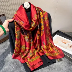 Close-up of red satin scarf with golden phoenix pattern and smooth glossy finish