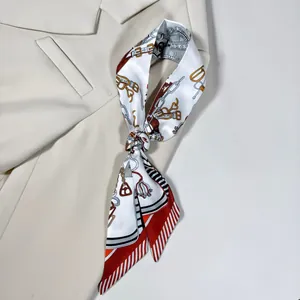 Détail d'un foulard en soie avec motifs équestres et bordures à rayures rouges