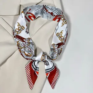 Détail d'un twilly en soie à motif équestre noué sur le col d'un blazer beige