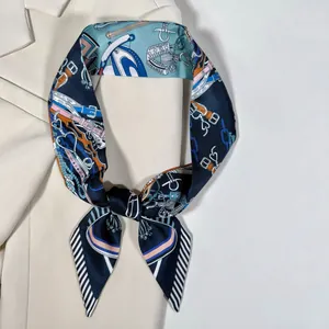 Détail d'un foulard en soie bleu marine avec imprimé équestre sur une veste crème