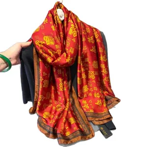 Elegant red satin scarf with golden Chinese blessing patterns draped over a grey suit