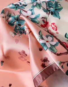 Detail of silk-like satin floral scarf featuring peach blossom print and smooth texture