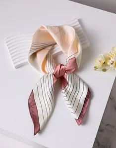 Detailed macro view of the floral silk scarf showing premium satin texture and patterns