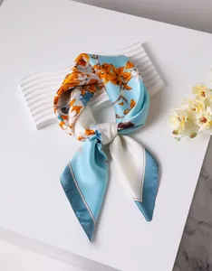 Detailed view of artistic floral silk scarf with soft satin finish on a wavy display tray