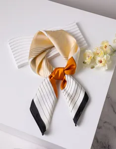 Detail of silk square scarf with champagne geometric patterns and smooth glossy finish