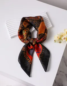Detail of vintage paisley silk square scarf with colorful patterns on black fabric