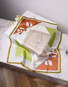 Detail of artistic satin silk scarf with abstract floral patterns and rolled edges