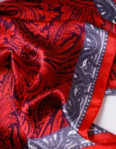 Gros plan sur le tissu satiné du foulard à motif cachemire rouge et violet très brillant
