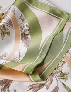 Close-up of silk-satin scarf with narcissus floral print and rolled edge stitching