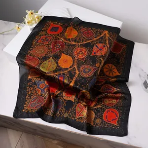 Vintage paisley print black silk square scarf with colorful ethnic patterns on white podium