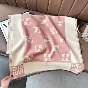 Détail d'une écharpe en cachemire avec franges et motif logo géométrique rose doux