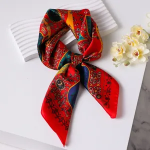 Vintage red paisley silk-like square scarf with elegant floral patterns on a white stand