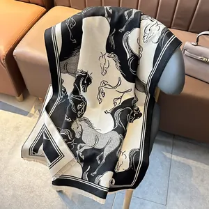 Luxurious wool shawl with monochrome horse print and fringe on a designer chair