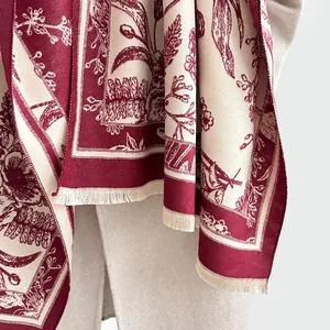 Macro detail of dark red floral vintage pattern and soft fringe on the cashmere-feel shawl