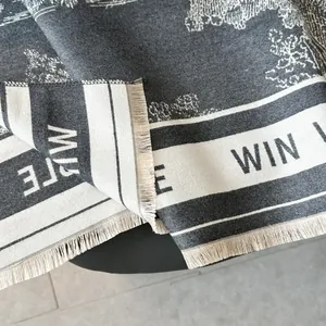 Macro view of thick knit scarf texture featuring MUTE embroidery and fringe tassels