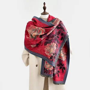 Détail de l'écharpe rouge à motif floral peinture à l'huile et fines franges sur manteau