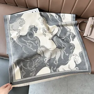 Close-up of gray and white jacquard horse pattern scarf with soft fringe details