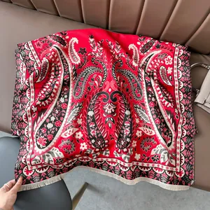 Detail of red paisley cashmere-feel scarf showing thick texture and tassel fringe