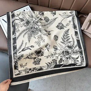 Close-up of vintage floral cashmere-feel shawl with delicate short fringes on leather surface