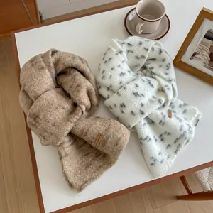 Dettaglio della sciarpa in maglia morbida a pois con etichetta in pelle decorativa