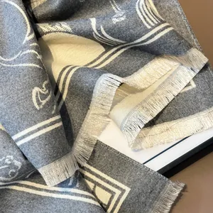 Macro detail of geometric jacquard pattern and soft fringe on the wool blend scarf