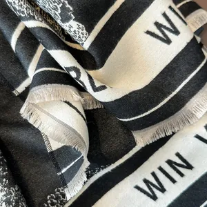 Detail of jacquard weave fabric with animal print and fringe edge on cashmere-feel scarf