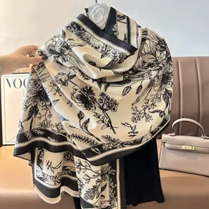 Close-up of black and white floral pattern shawl with soft fringes and artistic leaf design