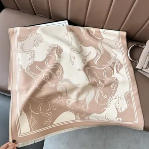 Detail of beige wool shawl featuring elegant horse patterns and fine fringe edges
