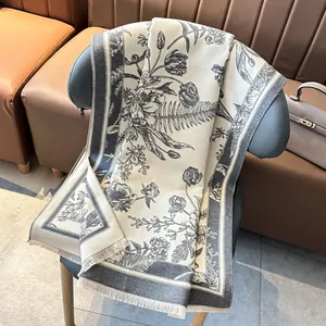 Ethnic vintage floral faux cashmere shawl scarf with tassels on a leather chair