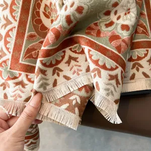 Detail of thick cashmere-like scarf showing boho floral jacquard and soft tassels