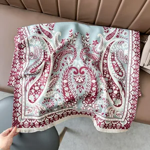 Close-up of thick paisley cashmere scarf with delicate tassels and wine red floral pattern