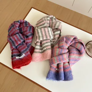 Vue détaillée d'écharpes en laine à rayures colorées, texture duveteuse et franges