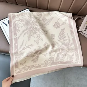Detail shot of vintage floral cashmere scarf with delicate fringes on a leather sofa