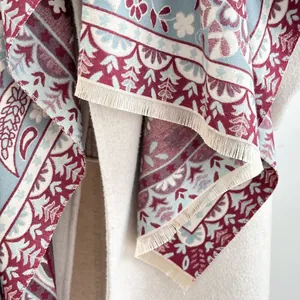 Close-up of thick paisley jacquard scarf with fringe trim on beige wool coat