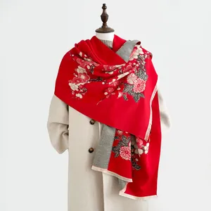Scialle floreale rosso e grigio effetto cashmere con frange su un manichino