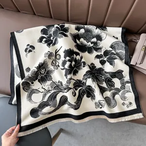 Detail of elegant black and white floral pattern with fringe on soft cashmere-like scarf