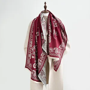 Close-up of double-sided paisley shawl with burgundy floral patterns and fringe details