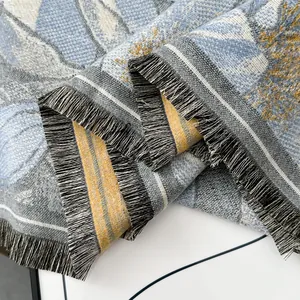 Vista macro dettagliata della trama in maglia jacquard e delle frange fitte sullo scialle