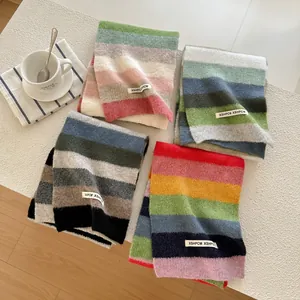 Soft knitted wool scarves with colorful stripes in various winter patterns on white table