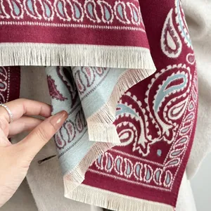 Detail of burgundy paisley scarf featuring thick cashmere-like texture and ivory fringes