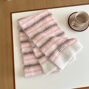 Détail d'une écharpe rayée en laine mélangée rose, blanche et grise avec texture en tricot